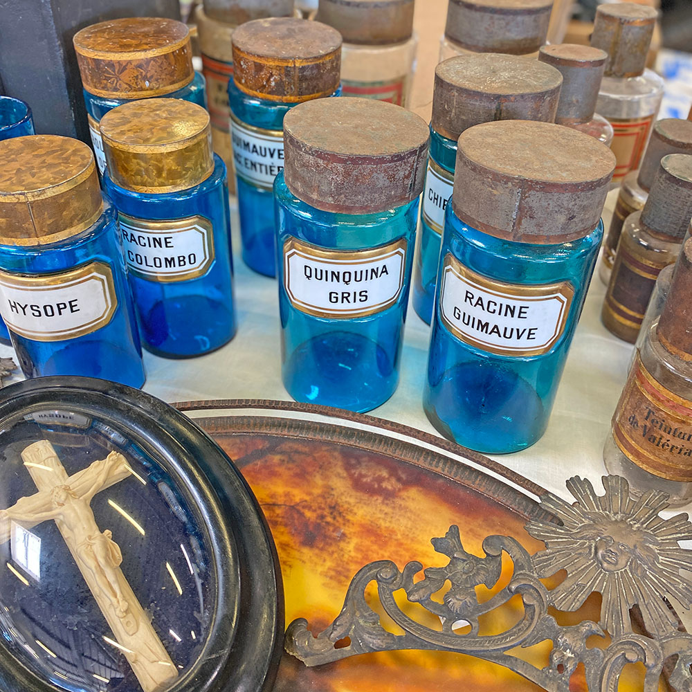 Détail objet vintage au déballage marchand de Montpellier réservé aux antiquaires et brocanteurs flacon verre anciennes officines