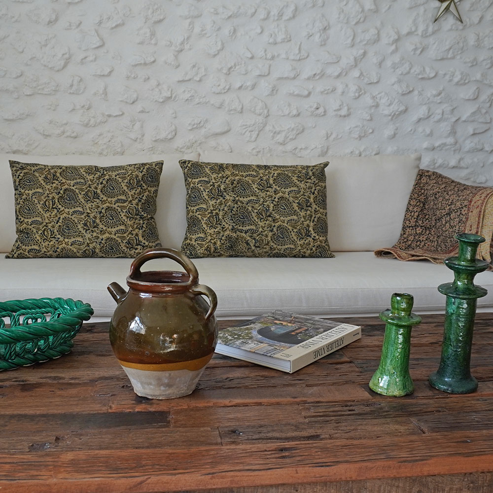 Pot ancien en faience devant coussin rectangulaire 50x70 cm en coton, création exclusive et artisanale réalisée à partir d'un tissu traditionnel du Rajasthan en Inde. Motif arabesques dits Paisley tons brun et bleu sur fond couleur sable, impression méthode du Block Print. Tissu d'Inde mais coussin confectionné à la main dans le Gard, chaque pièce est unique. Coussin complet avec housse en coton fermeture éclair à la base et garnissage